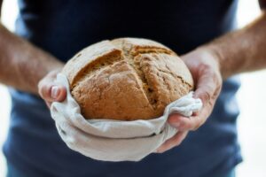 A person holding a loaf of bread